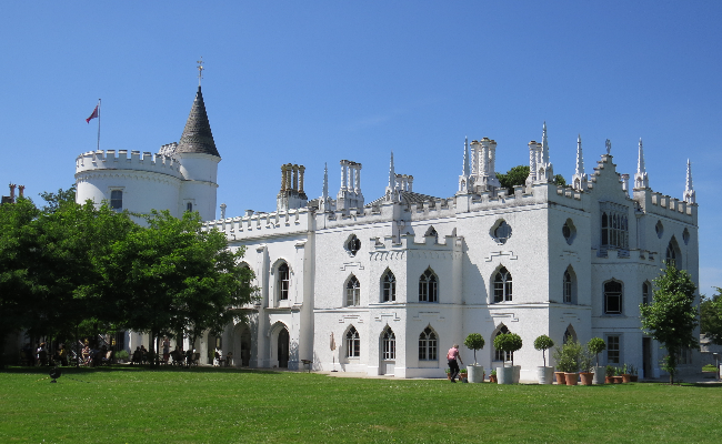 A large white castle looking building with a large lawn
