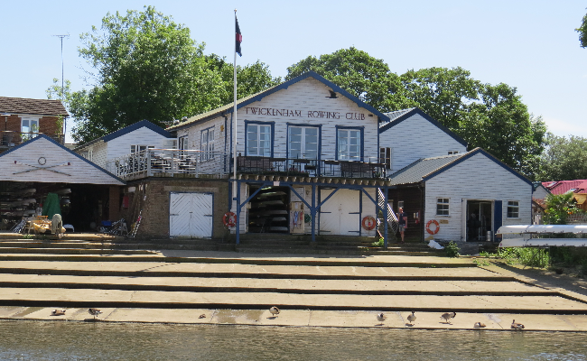 The rowing club in Twickenham, a white building right next to the water.